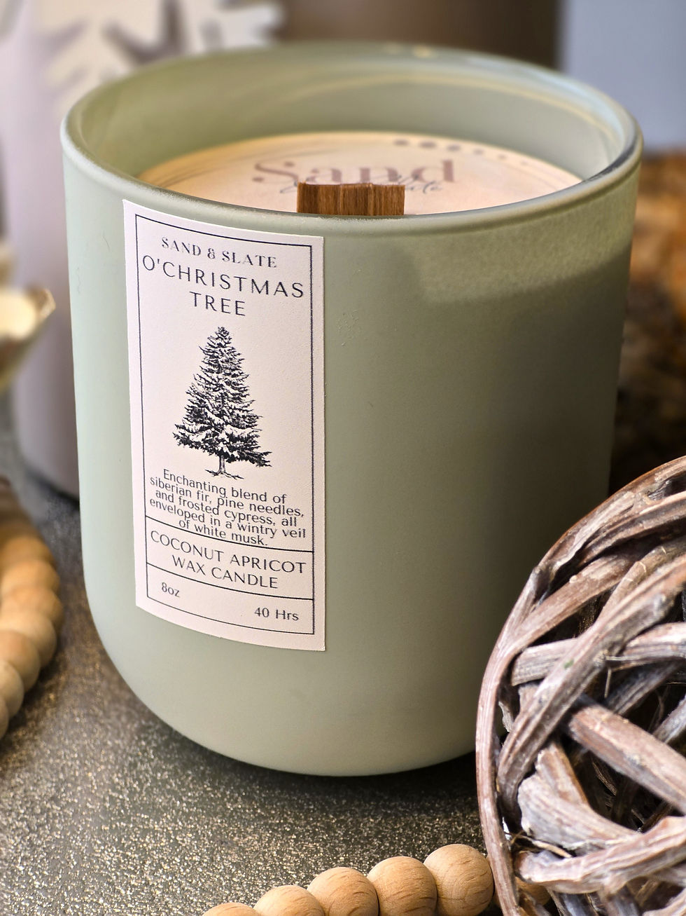 Close up of Victorian Christmas candle in sage green glass candle vessel.