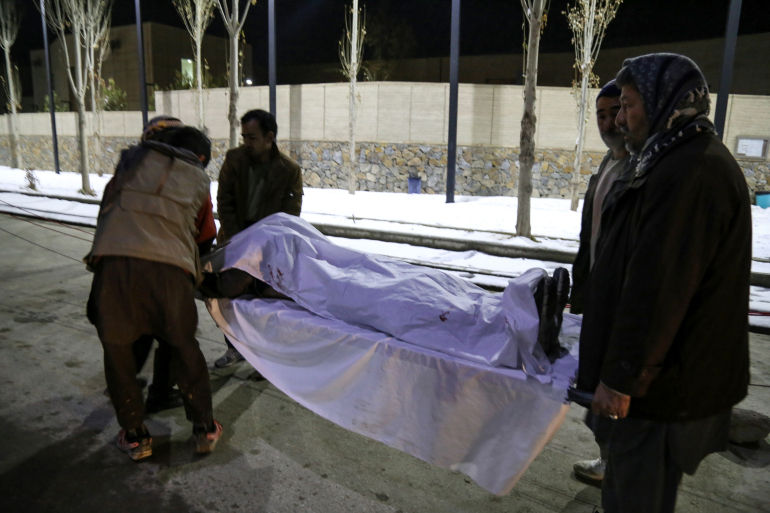 Volunteers carry the body of a victim to a hospital after two explosions occurred in the historic city of Bamiyan [AFP]