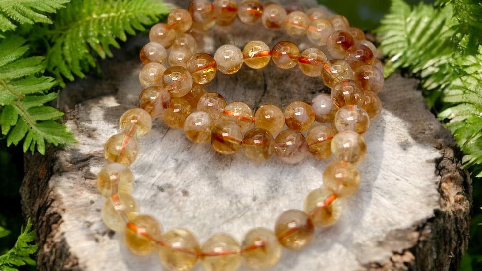 A radiant citrine bracelet glistens as it rests on a tree stump, surrounded by lush green ferns, capturing the essence of natural elegance.