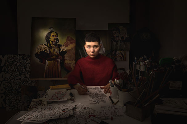 Charlie Casanova drawing and painting inside dimly lit studio shot by Lara Wilde