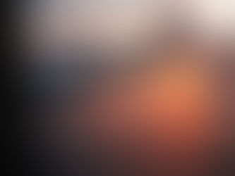 Airplane wing viewed from a window, flying over a calm ocean at sunset with dramatic clouds. The sky glows orange and pink.