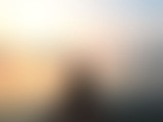 A solo traveler sitting on a wooden pier overlooking Lake Kivu during sunrise, surrounded by calm water and misty hills.