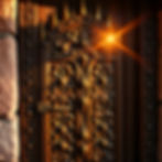 Ornate wooden door with intricate carvings and golden sunlight streaming through, creating a warm glow. Medieval theme, castle-like setting.