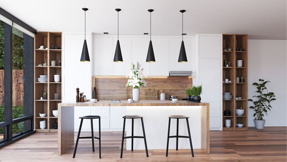 Modern kitchen with wooden floors, white cabinets, and three black pendant lights. A large island has bar stools and flowers. Bright, airy feel.