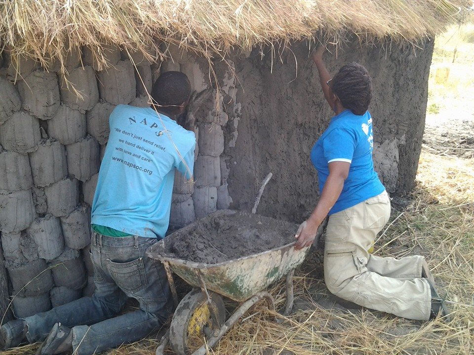 Volunteers add mud to the home
