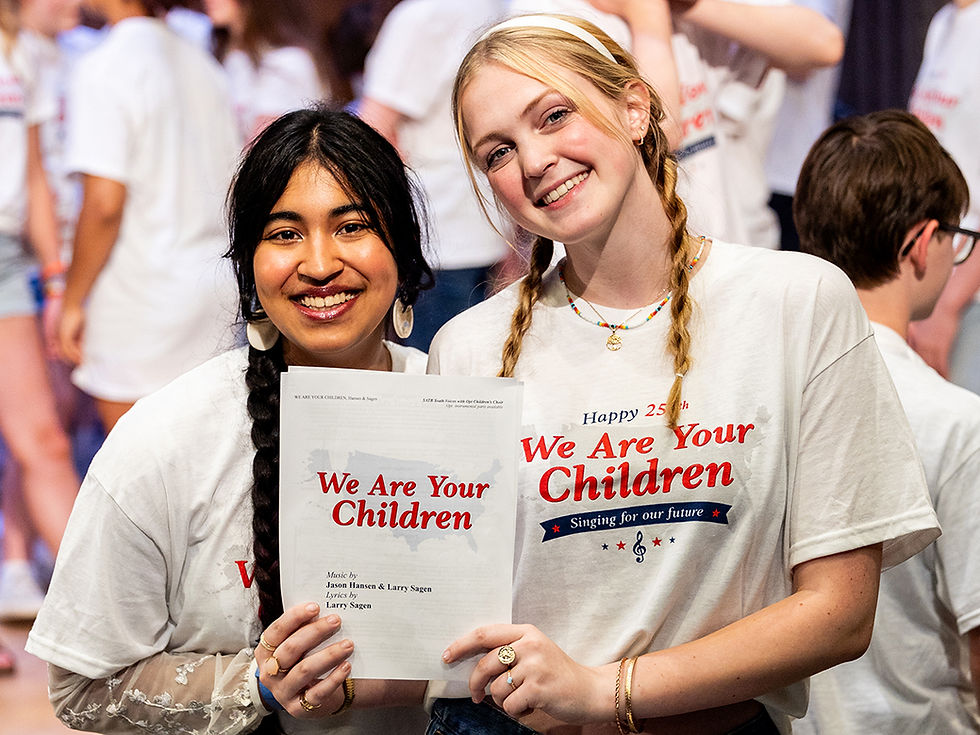 Two smiling girls holding a We Are Your Children program.
