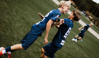 Baller Camp zwei Kinder spielen gemeinsam Fußball