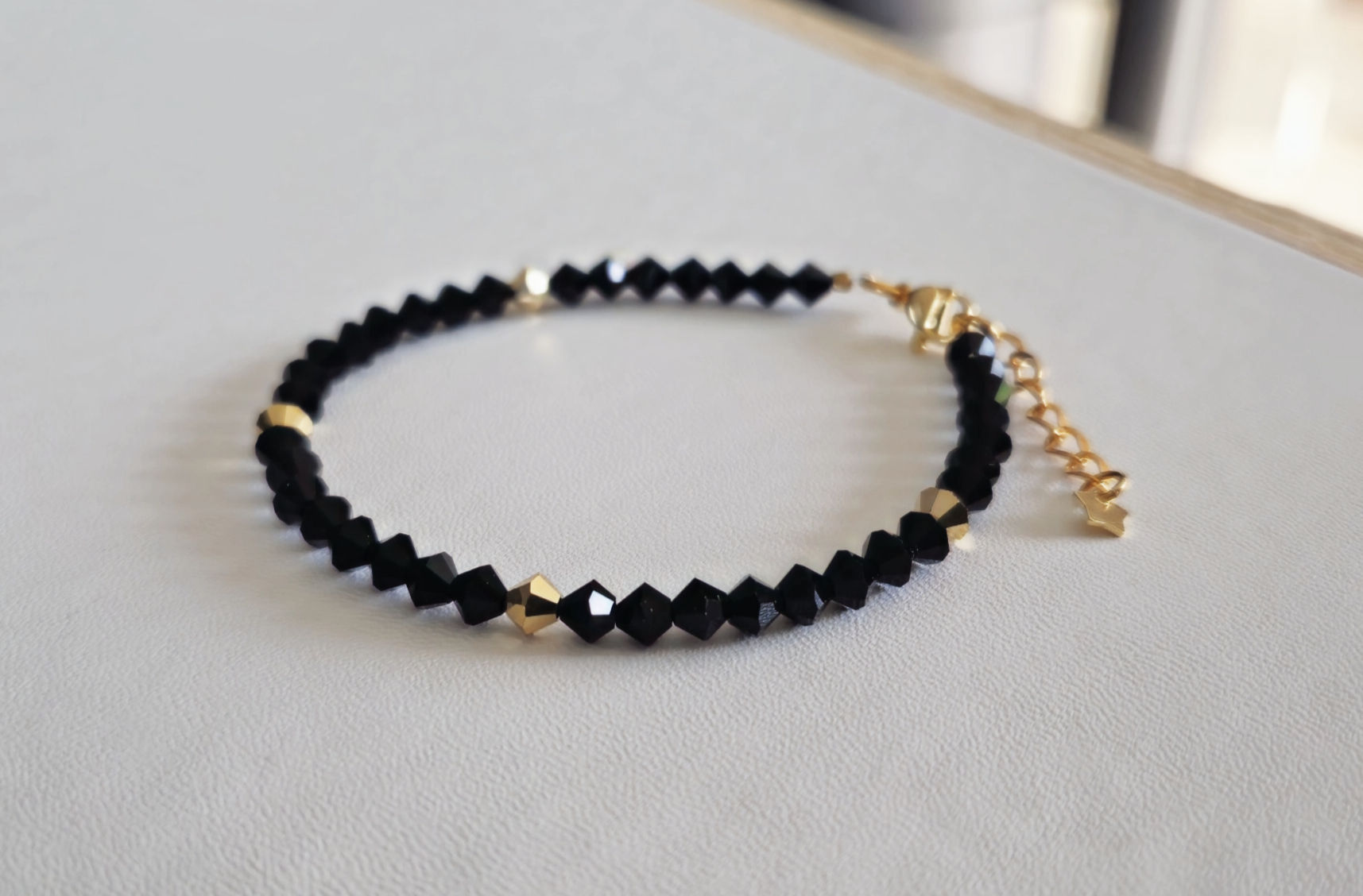 Bracelet noir et ses quelques perles dorées