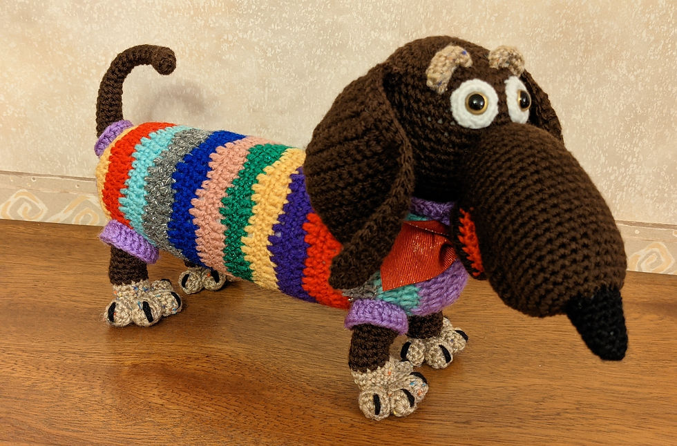 Crocheted Sausage dog wearing a colourful stripey jumper