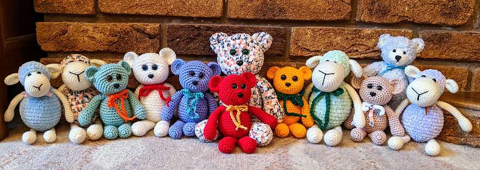 12 crocheted toys in different colours, lined up against a wall