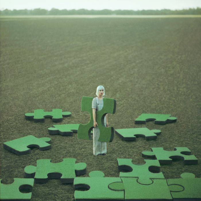 kobieta uklada puzzle na trawniku