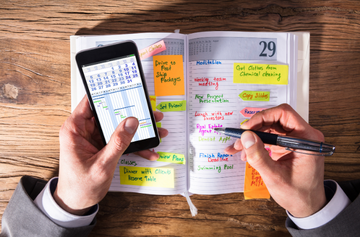 A man writing in his scheduler