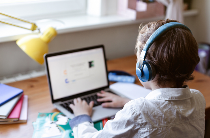 Little boy doing doing homework in laptop computer