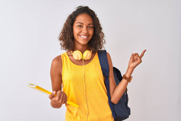 College student smiling and pointing upwards