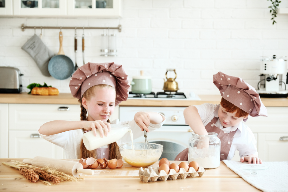 Two young girl chefs mixing flour in a bowl