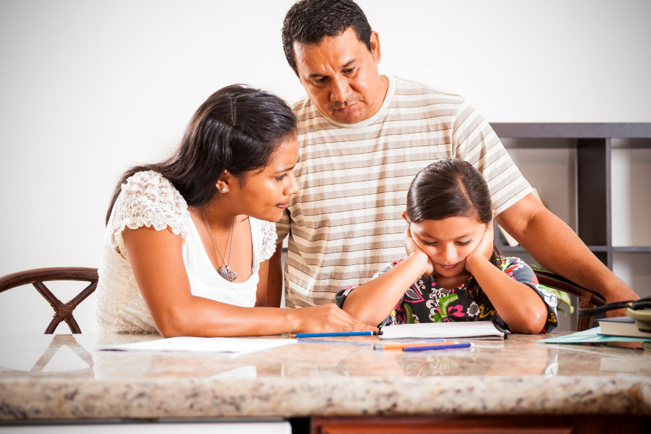 Mom and dad helping young child with homework