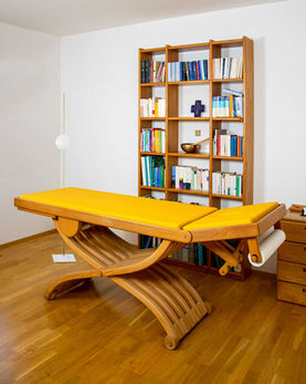Behandlungszimmer mit gelber Liege in der Ordination Dr. Karin Heigl.jpg.jpg