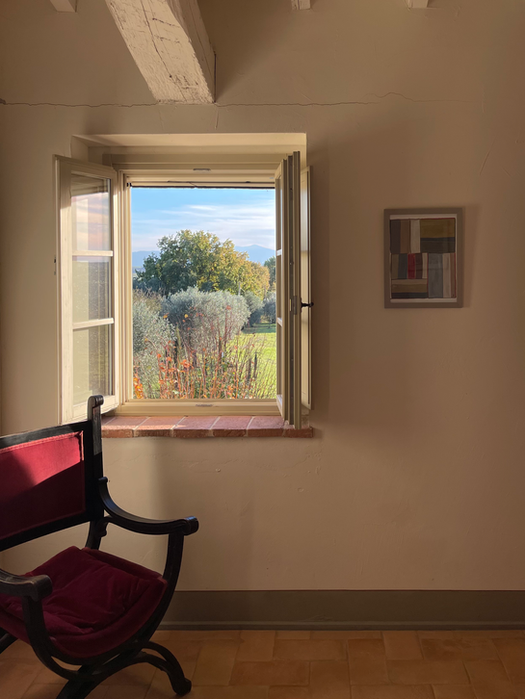 Soft morning light in a quiet guest room at L’Oliveto retreat venue