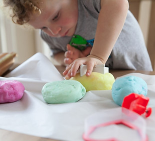 toddler playing with colored putty