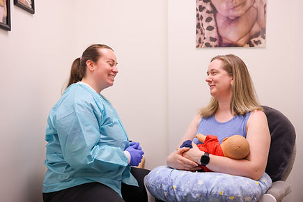 A nurse and a female patient women smiling in a doctor's office