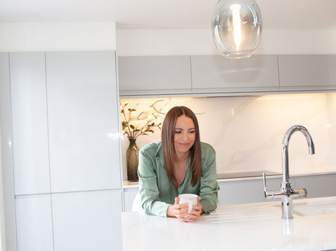 Vicky in modern kitchen holding a mug.