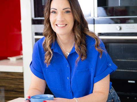 Sam in blue shirt holding a mug.