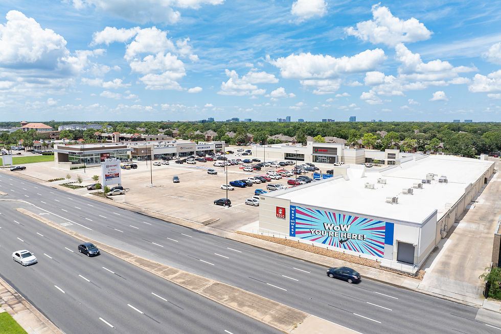 Photo of strip center with colorful mural through the parking lot