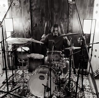 Recording studio session featuring musician playing live instrument