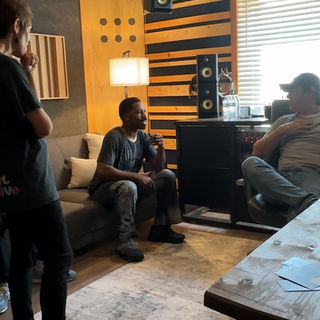 Audio engineer and artist collaborating during music recording session
