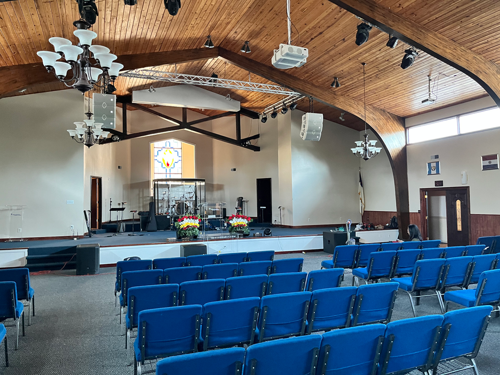 Line array speakers installed above church stage for even sound coverage