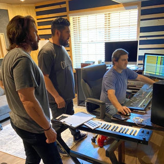 Audio engineer and artist collaborating during music recording session
