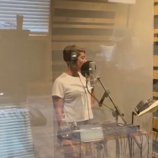 Singer recording vocals in professional music studio during session