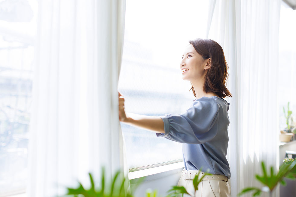 カーテンを開ける女性