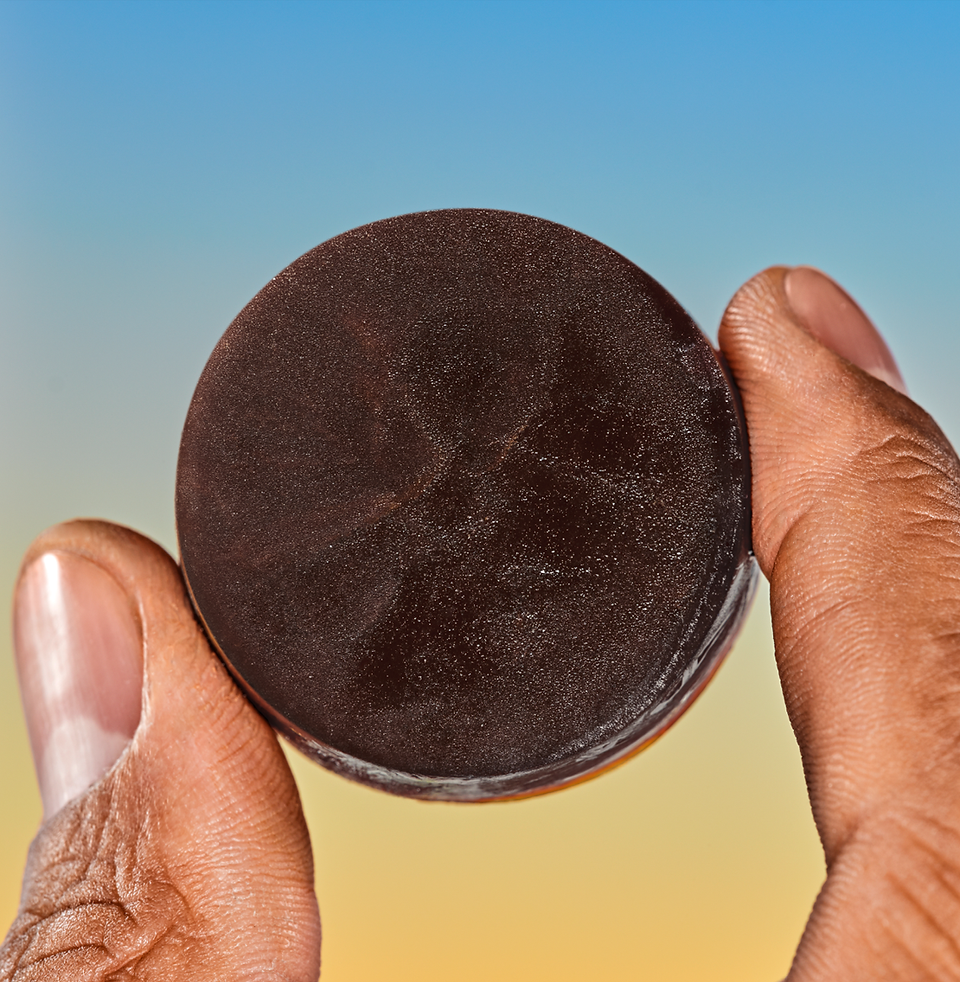 Image by Bobby Doherty depicting a coffee capsule held between two finders for DTC coffee company Cometeer. 