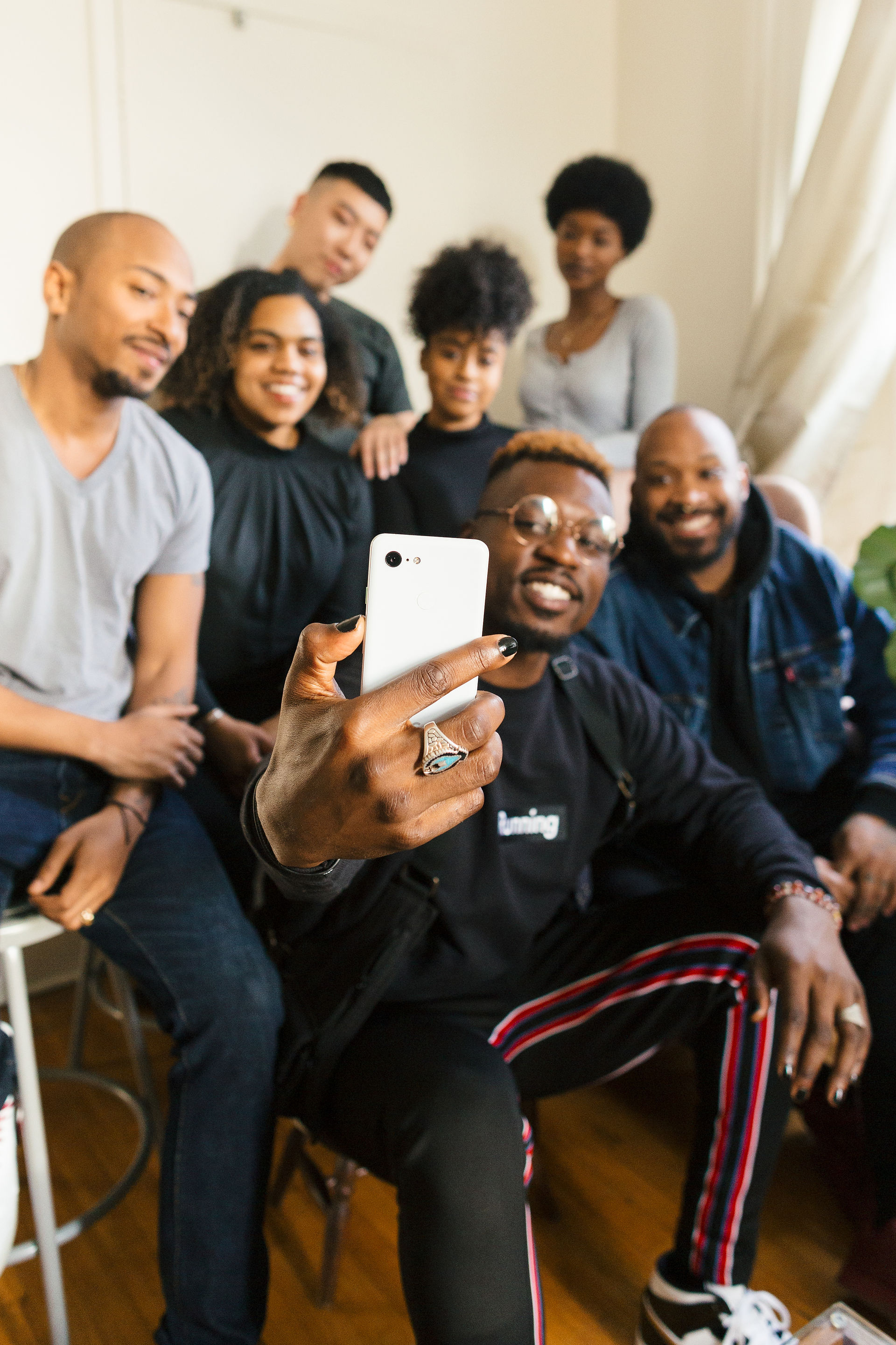 A group of people with a variety of skin tones pose for a selfie with the Pixel 6 Pro real tone camera.
