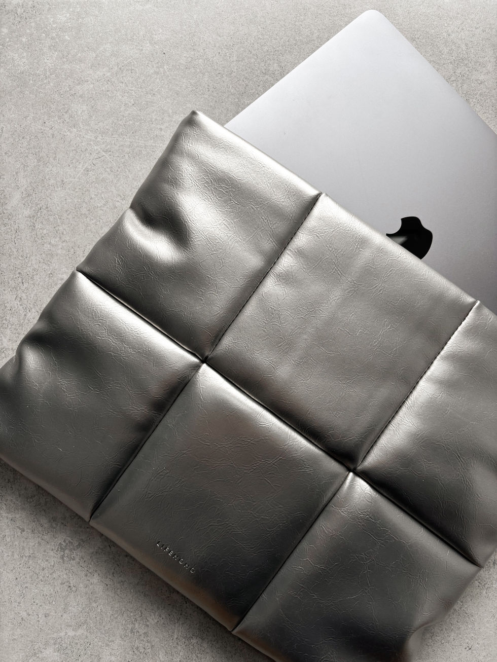 MacBook у срібному конверті PILLOW CASE, вигляд у використанні з акцентом на форму та мінімалістичний дизайн.