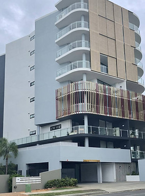 Multi-story modern apartment complex in Redcliffe featuring expert commercial cement rendering and a precise, high-contrast exterior paint system applied by JT Industries & Co.
