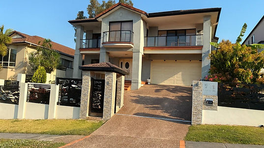 Exterior of a two-story residential home showcasing a flawless, modern cement render by JT Industries & Co, highlighting our meticulous craftsmanship on residential facades.
