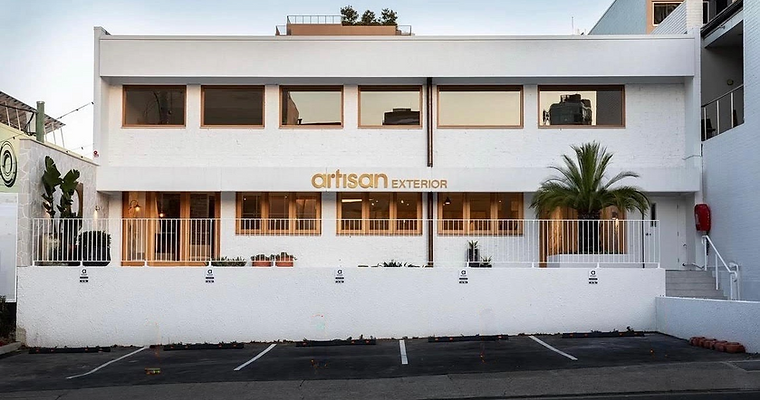 Artisan Exterior located in brisbane city, full facade with stucco fnish. Timber stained window frames mising with the white walls