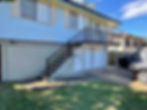 Residential exterior renovation in progress, showcasing a fresh, modern render finish on the ground floor walls that provides a clean contrast to the existing upper-level weatherboards and metal staircases.