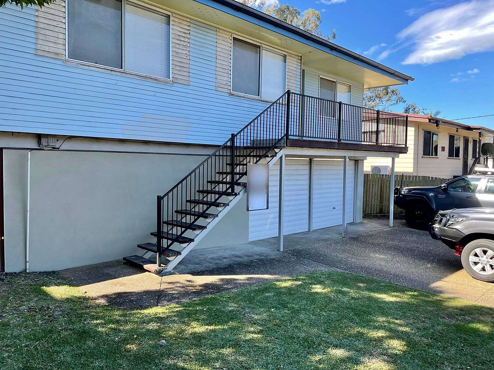 Residential exterior renovation in progress, showcasing a fresh, modern render finish on the ground floor walls that provides a clean contrast to the existing upper-level weatherboards and metal staircases.