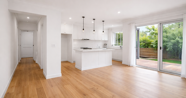 Professional interior house painting with smooth white walls, modern kitchen, timber floors, and bright open-plan living space.