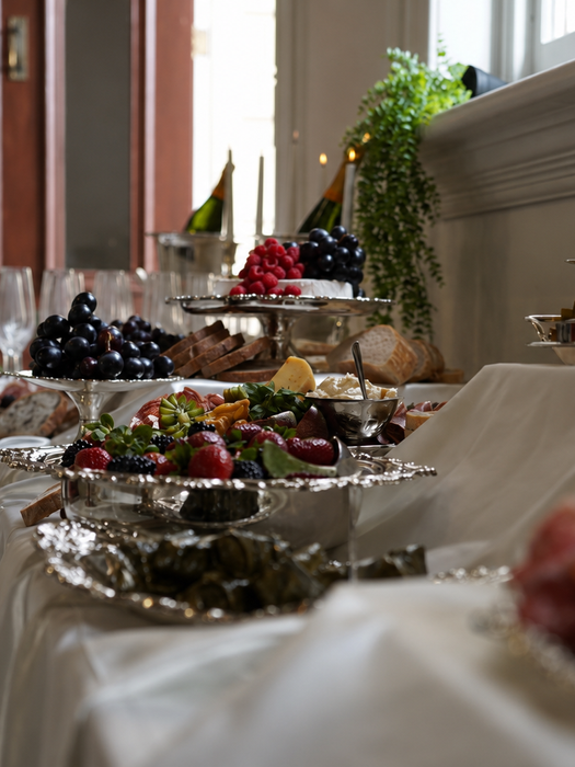 Elegant vintage silver grazing table with antique silver serving platters, fresh fruit, artisan cheeses, charcuterie, champagne flutes and candlelit styling for a luxury Melbourne wedding or special event.