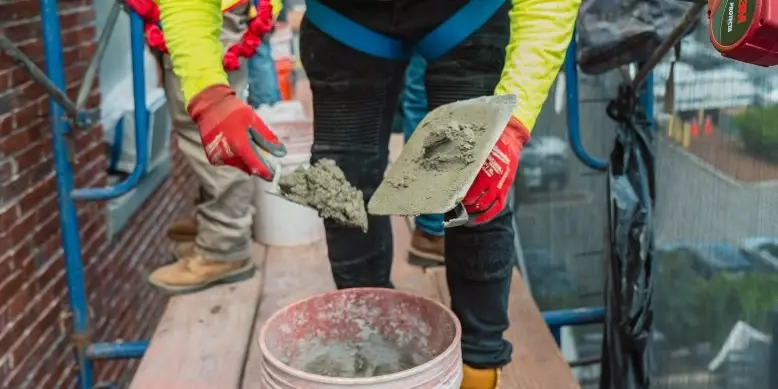 man getting mortar on trowel