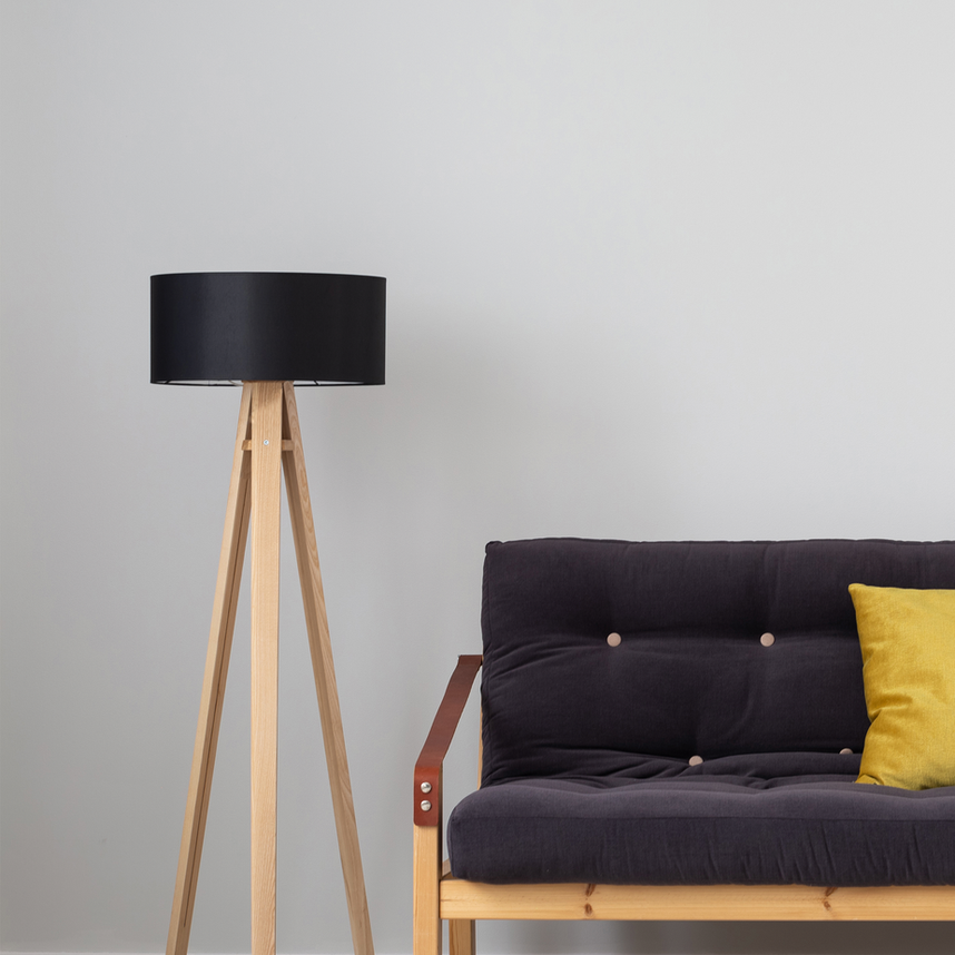 Black floor lamp next to dark gray sofa with yellow pillow