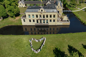 borg Nienoord in leek vanuit de drone. Je zien een groep bruidsgasten in een hartjesvorm