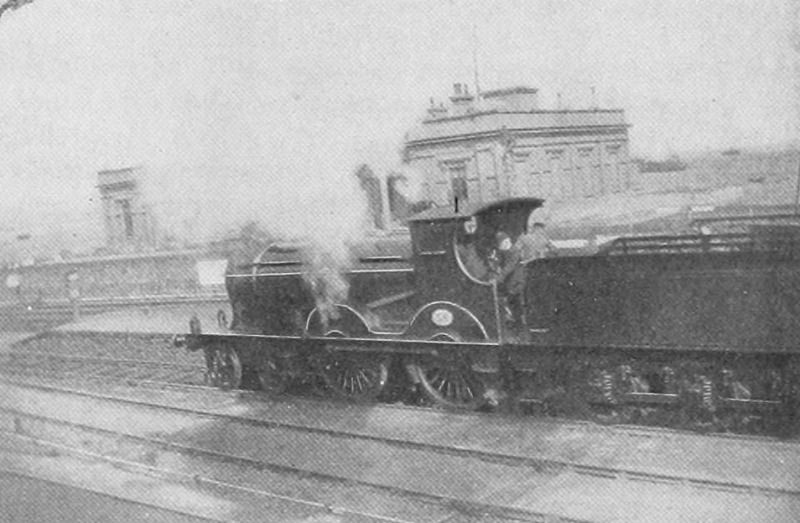 A black and white photo of a steam train in a station.