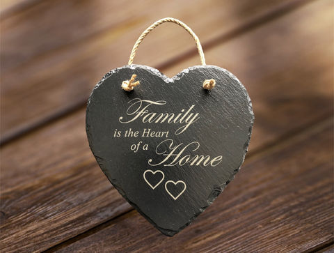 Sweet pea laser boutique Heart shape slate sign, with the words 'Family is the heart of a home' engraved. The slate heart can be hung by a piece of string.