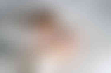 Broertjes knuffelen op een hydrofiele doek tijdens een newborn fotoshoot. 