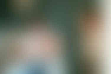 Vader houdt baby vast in de schommelstoel op de babykamer. 